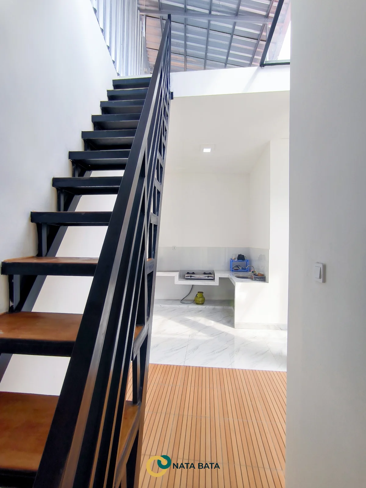 Tangga baja rumah minimalis dengan lantai motif kayu dan dapur terbuka