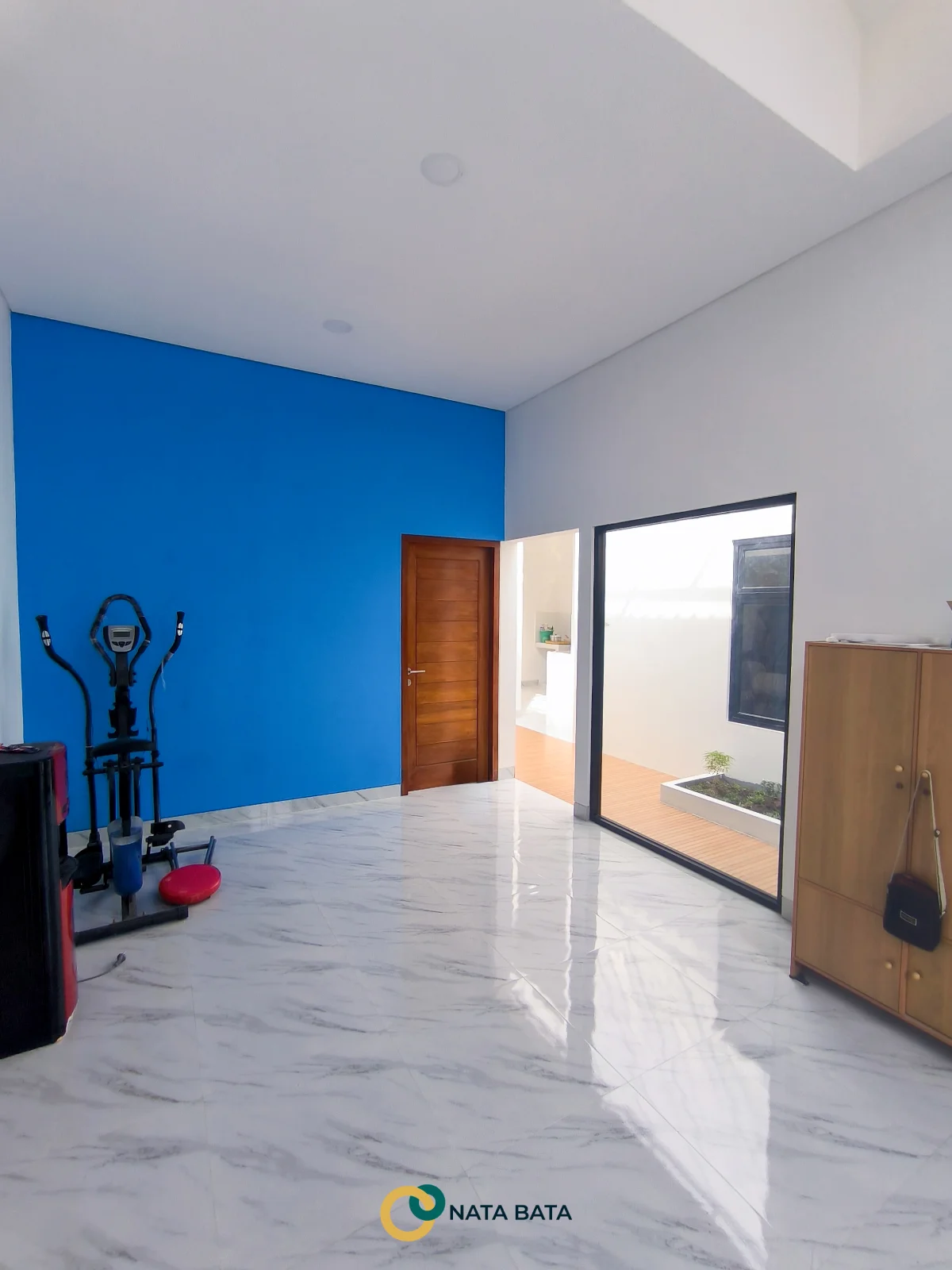 Ruang keluarga rumah minimalis dengan aksen dinding biru