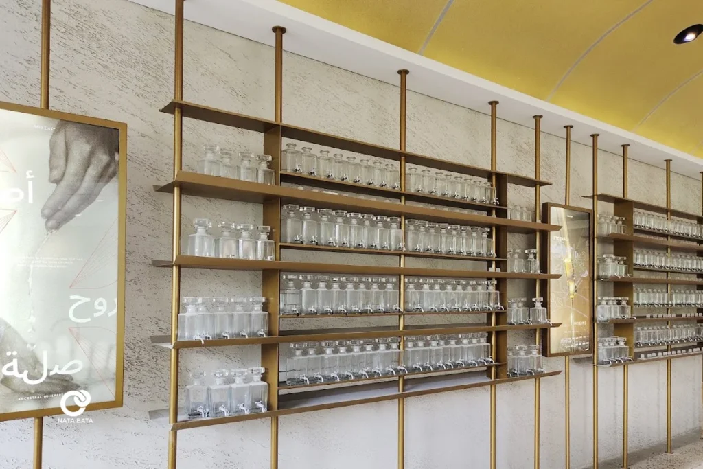 Desain interior showroom parfum dengan rak emas elegan dan dinding bertekstur khas, karya interior Nata Bata.